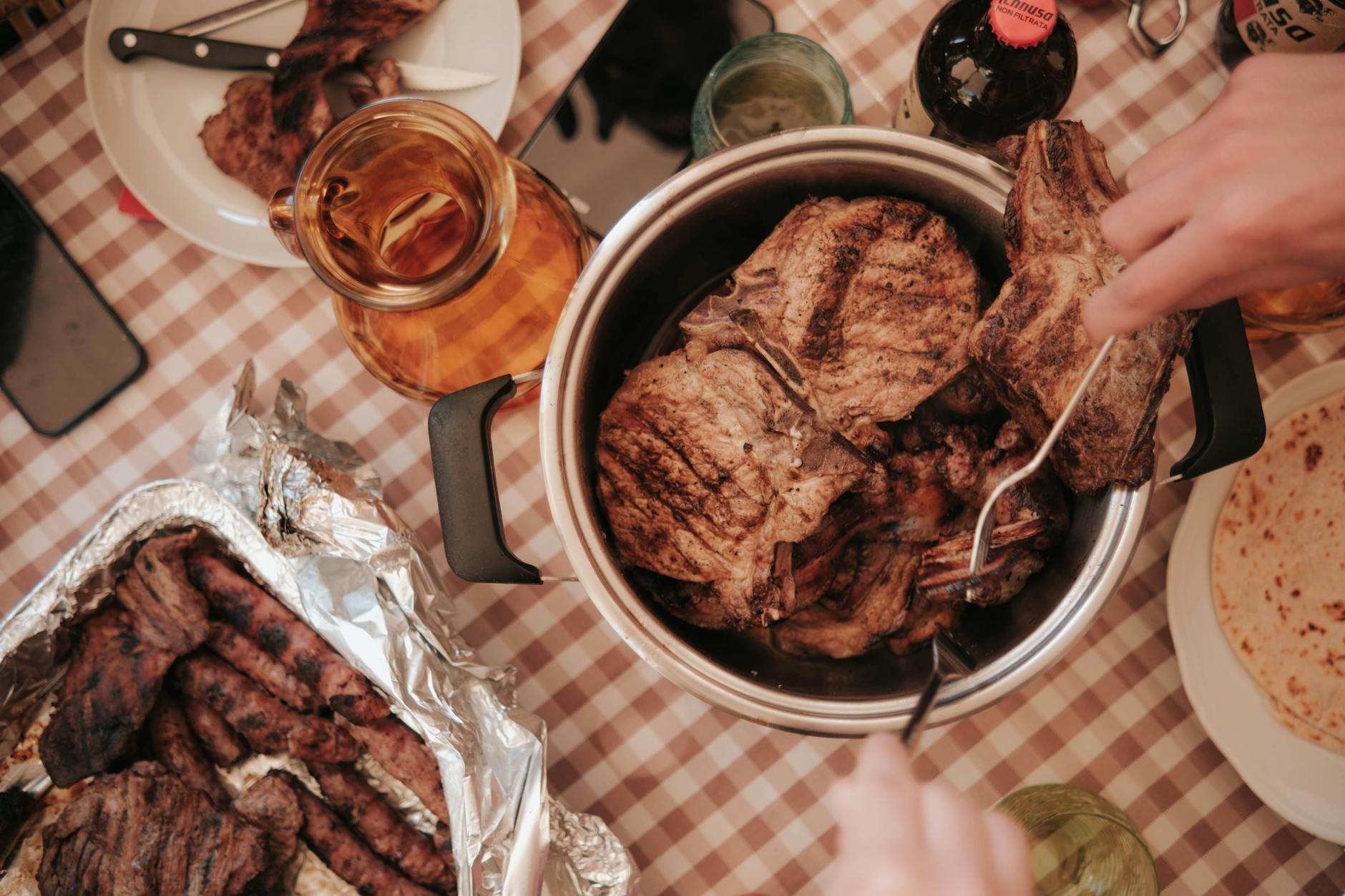 Stół z grillowanym mięsem i napojami widziany z góry