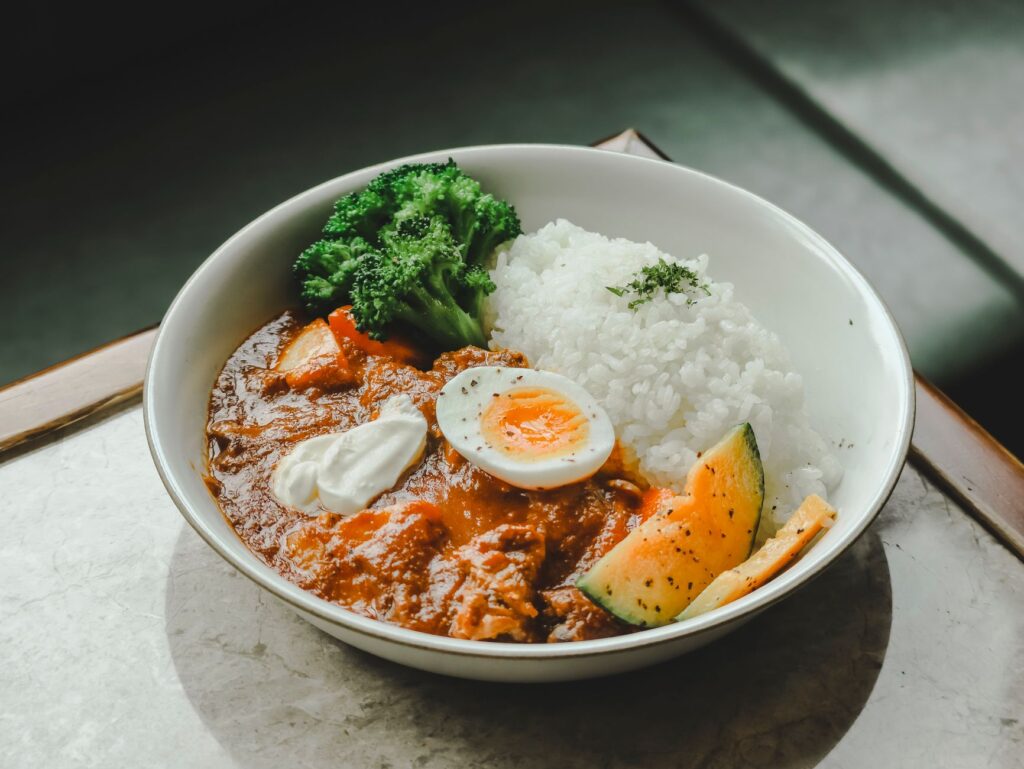 Curry z ryżem, warzywami i jajkiem na twardo w misce