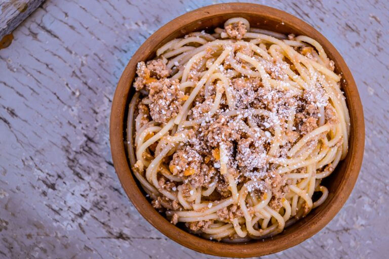 Spaghetti bolognese z parmezanem w rustykalnej drewnianej misce